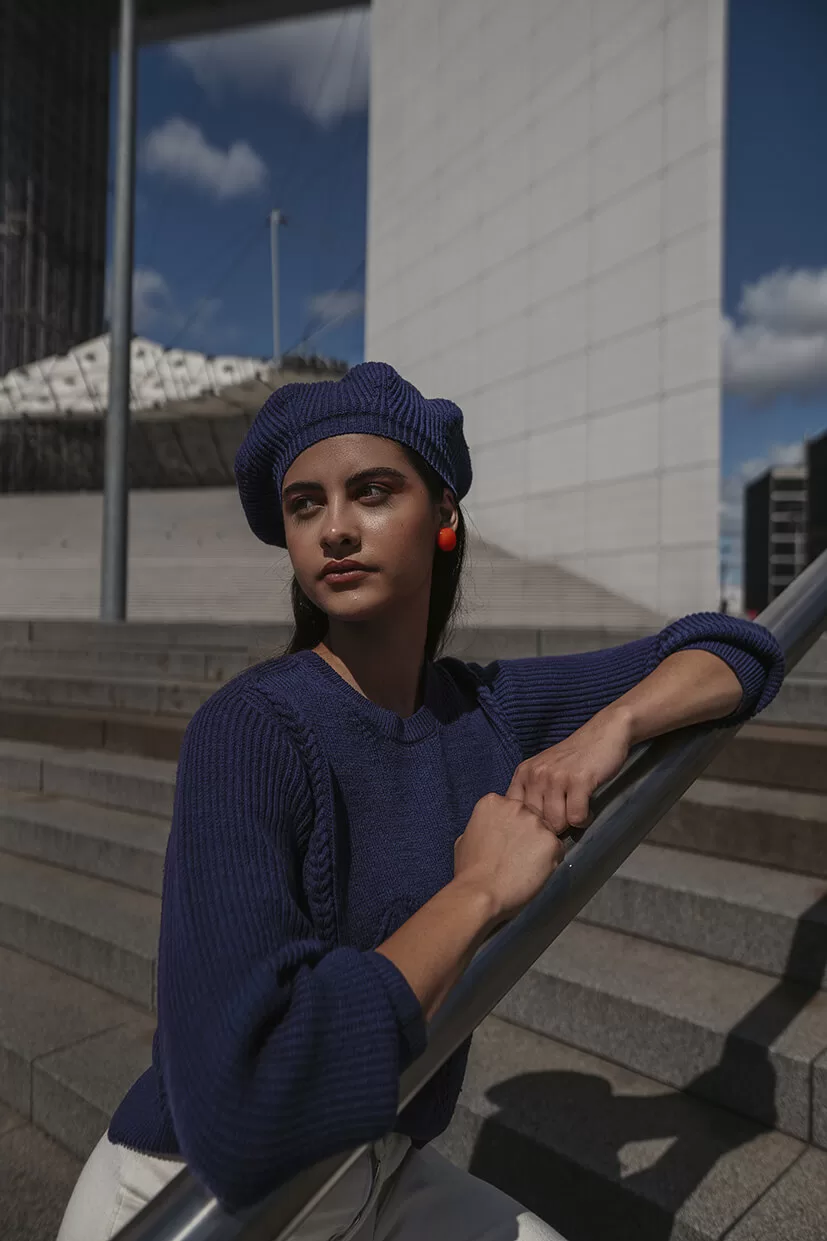 jeune femme avec pull et béret bleu marine assortis à la Défense Paris