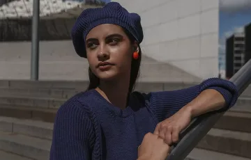 jeune femme avec pull et béret bleu marine assortis à la Défense Paris