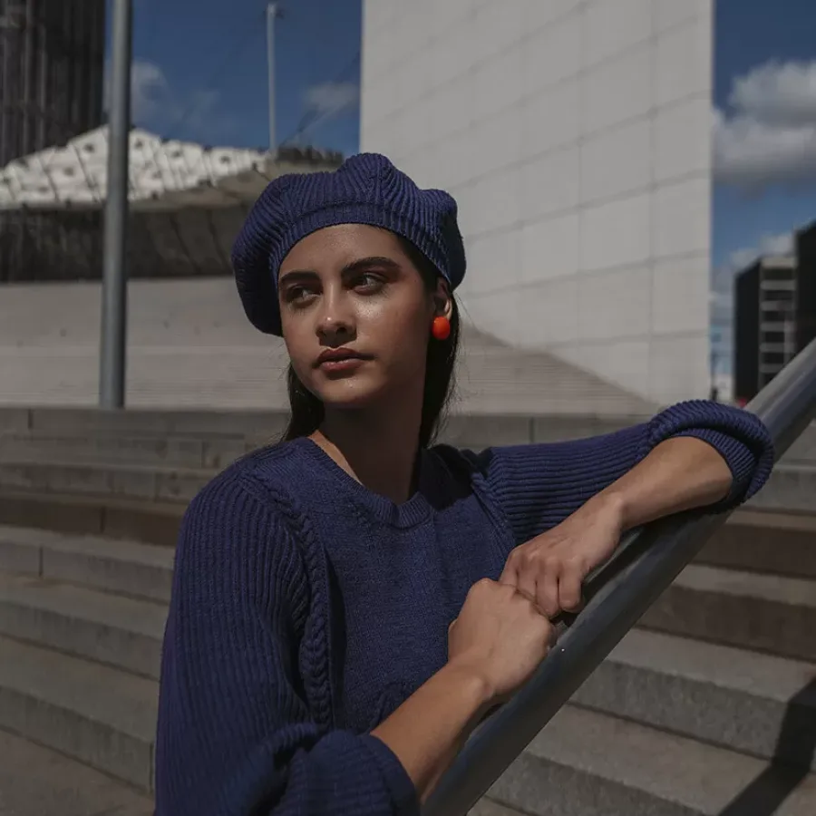 jeune femme avec pull et béret bleu marine assortis à la Défense Paris