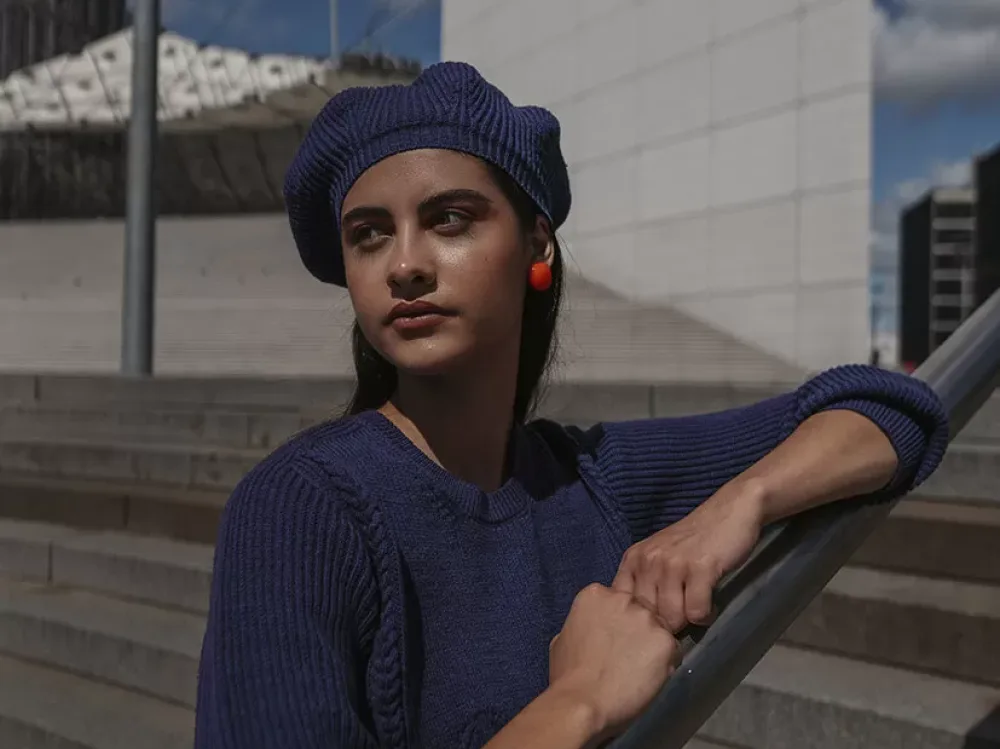 jeune femme avec pull et béret bleu marine assortis à la Défense Paris